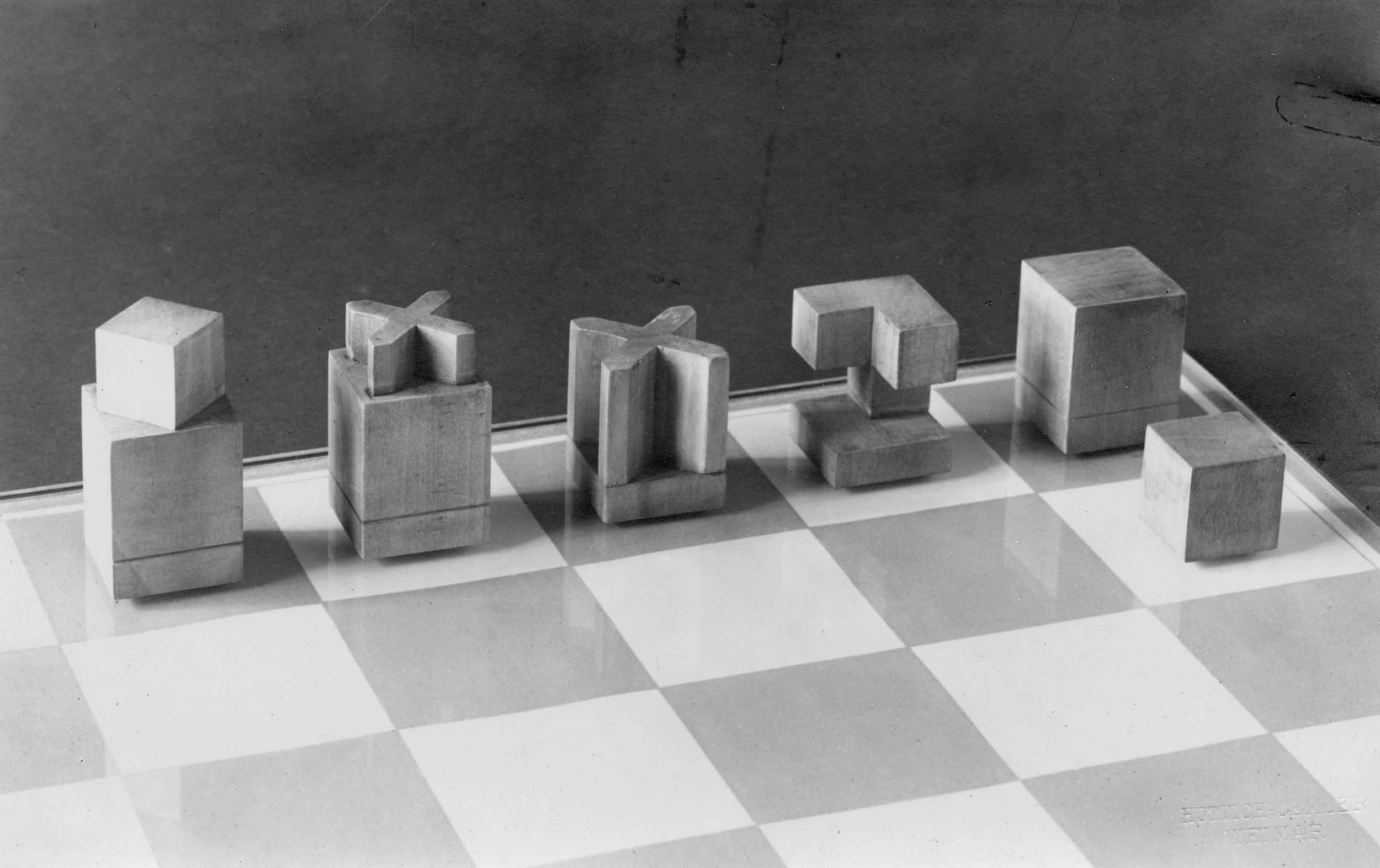 Archivbild eines Schachbretts mit geometrisch aufeinander abgestimmten Holzfiguren.